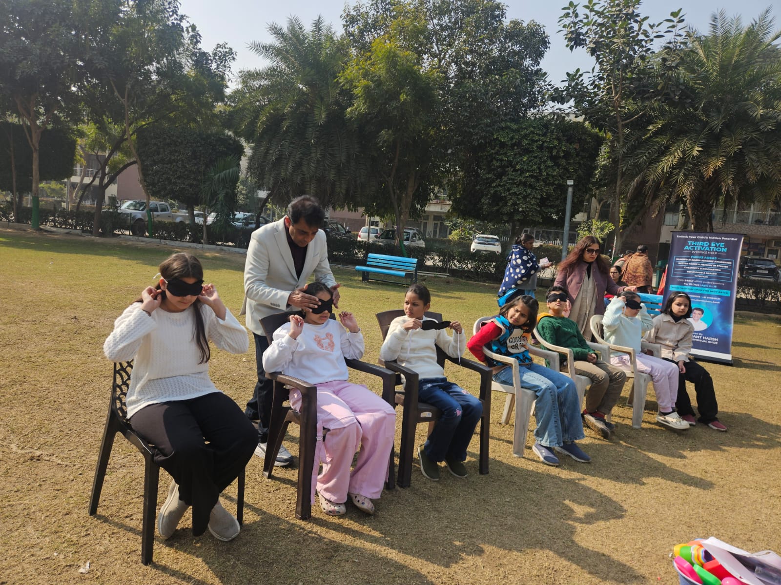 Chanderkant Harsh guiding children through an outdoor blindfold awareness exercise